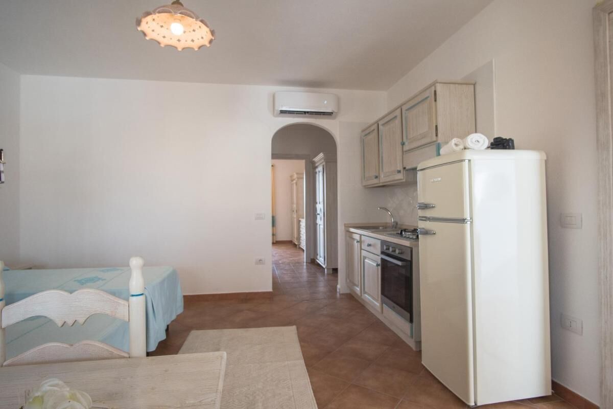 Una cocina compacta con refrigerador, horno y pileta.