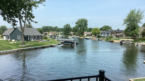 Un quartier résidentiel avec un plan d’eau paisible, des maisons et un quai.