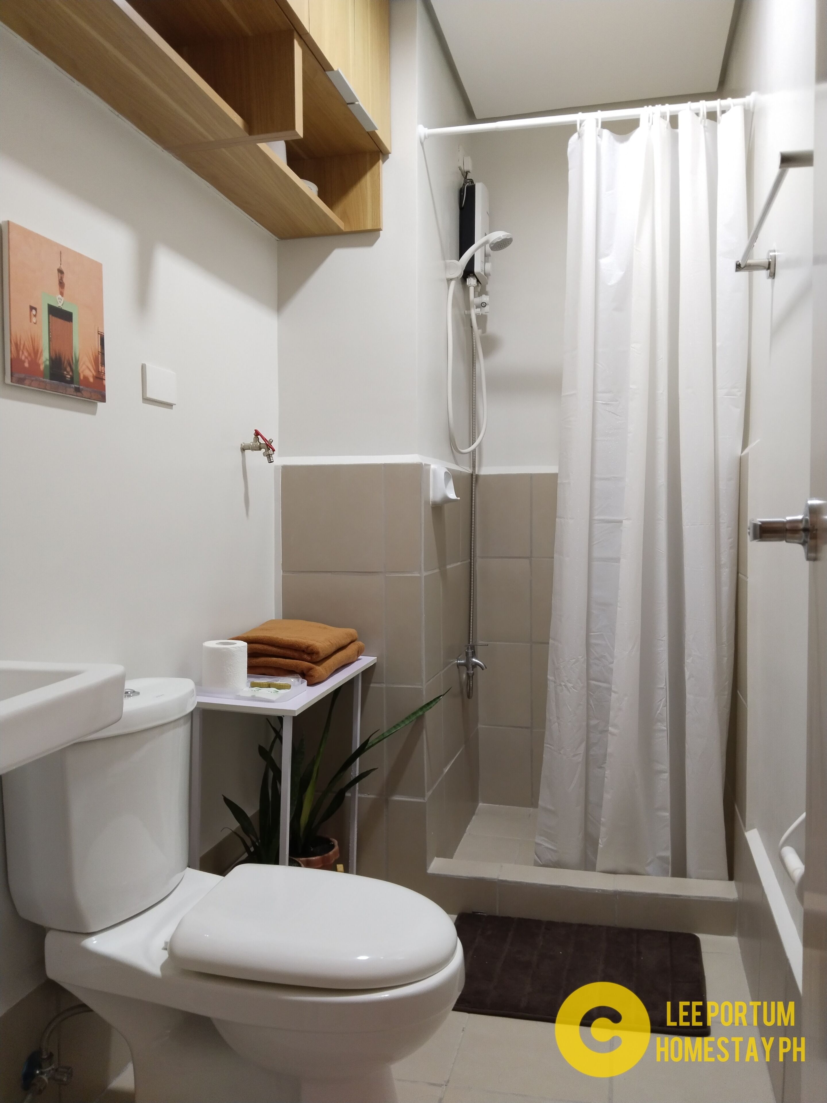 A bathroom with a toilet, sink, shower, and a towel rack.