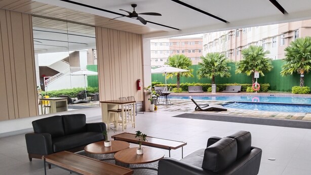A modern indoor pool area with seating and a ceiling fan. - Cozy Unit at SMDC Cheer Residences by Lee Portum (Marilao)