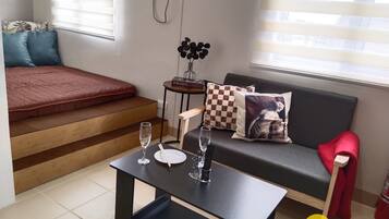Een moderne woonkamer met een bank, een salontafel en een bijzettafeltje met een boek en een vaas.
