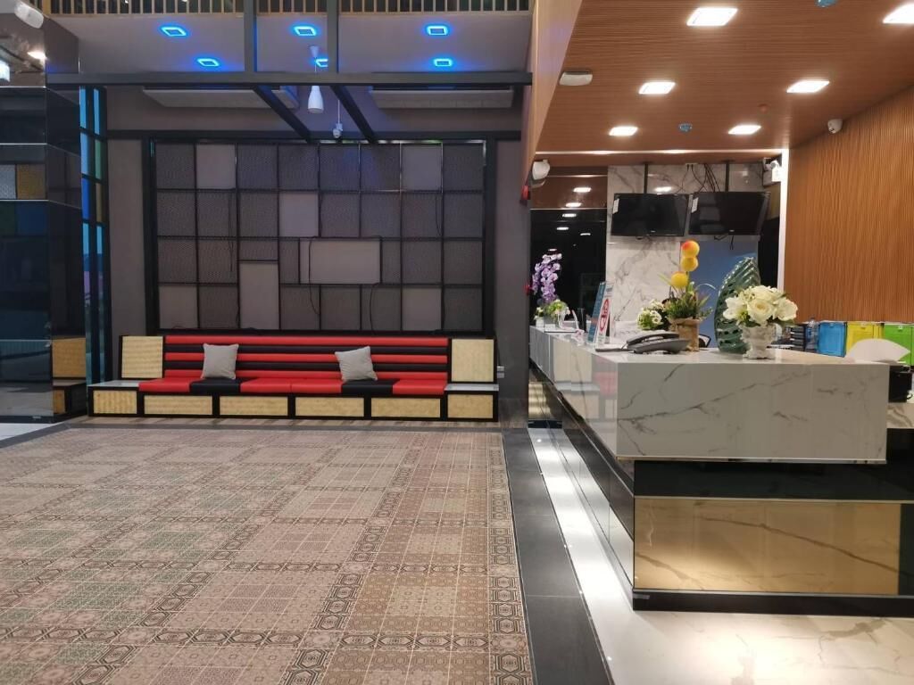 A reception area with a red bench, a marble counter, and a patterned carpet.