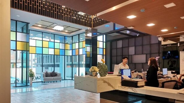 Un moderno vestíbulo de hotel con mostrador de recepción, zona de estar y grandes ventanales.