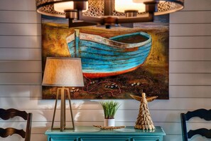 Cozy retreat with a rustic charm, featuring a wall-mounted painting, console table, and comfortable seating area.