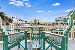 Enjoy al fresco dining and take in the coastal views from this balcony, featuring a round table and comfortable seating for two.
