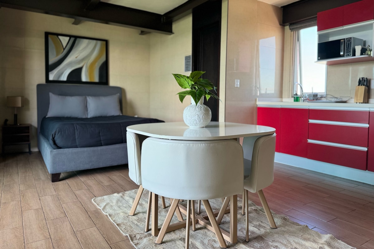 A modern bedroom with a bed, a bedside table, and a small bedside lamp.