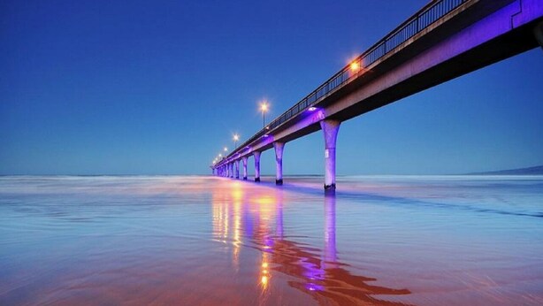 A long bridge with lights extending over a reflective water surface. - New House in New Brighton, Right by the Beach and Pier! (Christchurch)