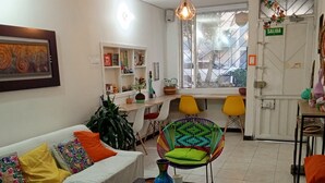 Una sala de estar con un sofá, sillas coloridas, una mesa de centro y un ventanal con vistas.
