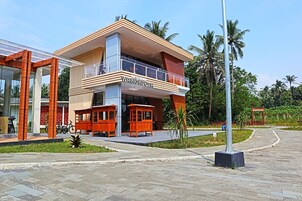 Un hotel moderno con una estructura de dos pisos, un balcón y un letrero que indica que es un 'Restoran Wringinputih'.