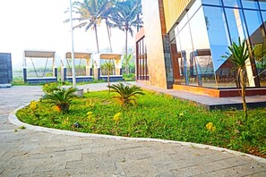A modern building with large glass windows, a paved walkway, and small palm trees. - Perta Prana Amarta (Borobudur)