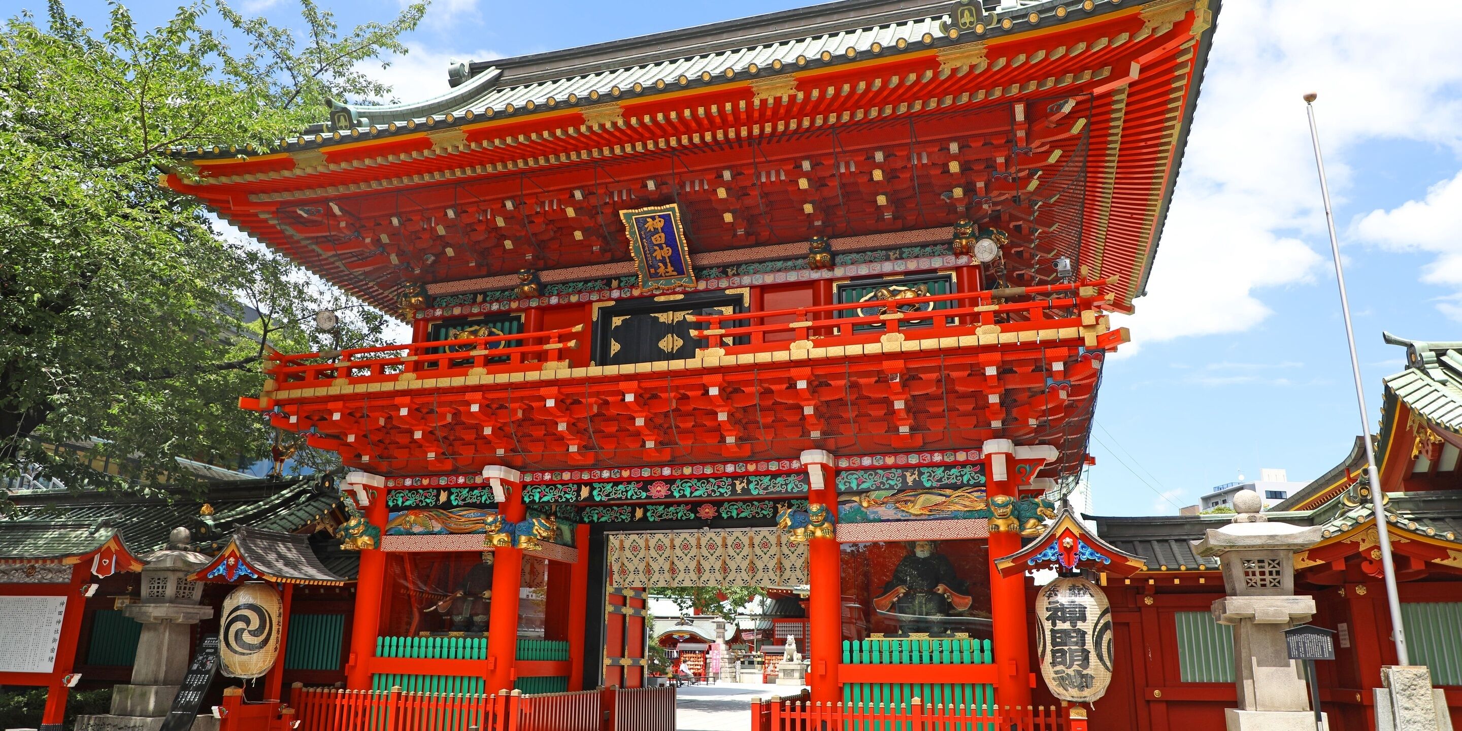 Un torii japonés tradicional con elaborados diseños en el tejado y un llamativo esquema de color rojo.