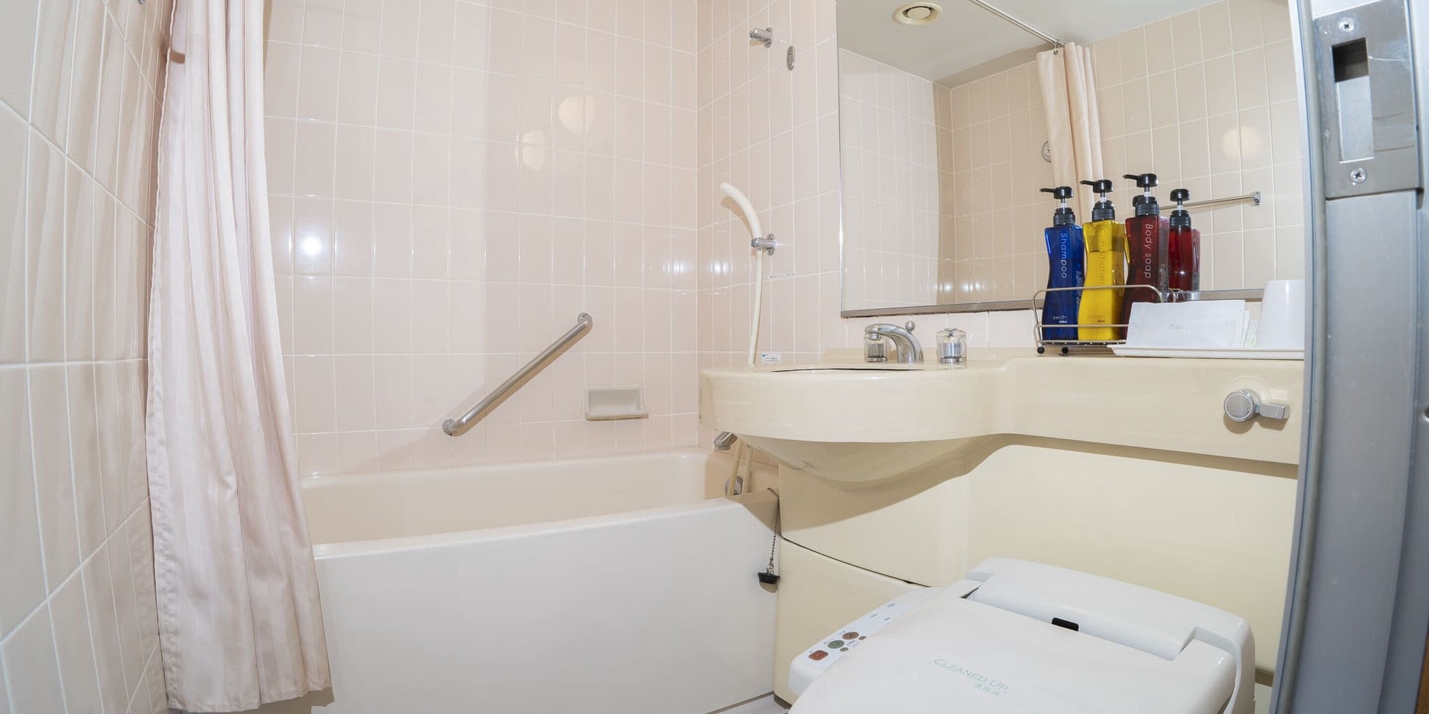 A bathroom with a bathtub, a shower, a sink, and a mirror.