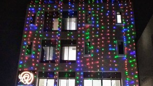 A building with colorful lights and a sign for the Pride Arena. - Hotel Pride Arena (Bhopal)