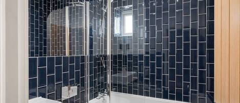 Une salle de bain moderne avec une douche à parois de verre, un lavabo blanc et des toilettes.