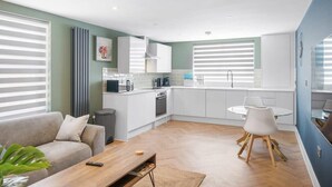 A modern apartment with a living room, kitchen, and dining area. - Spacious Apartment, 1 Minute from Seafront (Paignton)
