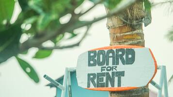 Une pancarte fixée à un poteau en bois, sur laquelle on peut lire : « PLANCHE À LOUER ».