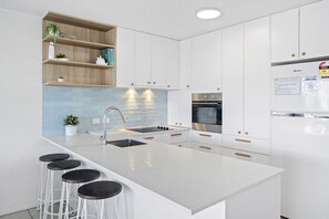 Enjoy cooking in this kitchen with a sink, ample counter space, and a stainless steel range hood.