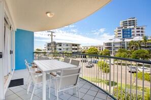 Enjoy a view of the city from this balcony with a table and chairs.