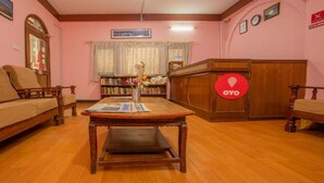 A cozy living room with a sofa, a wooden coffee table, and a bookshelf. - MeroStay 211 Hotel DN (Kathmandu)