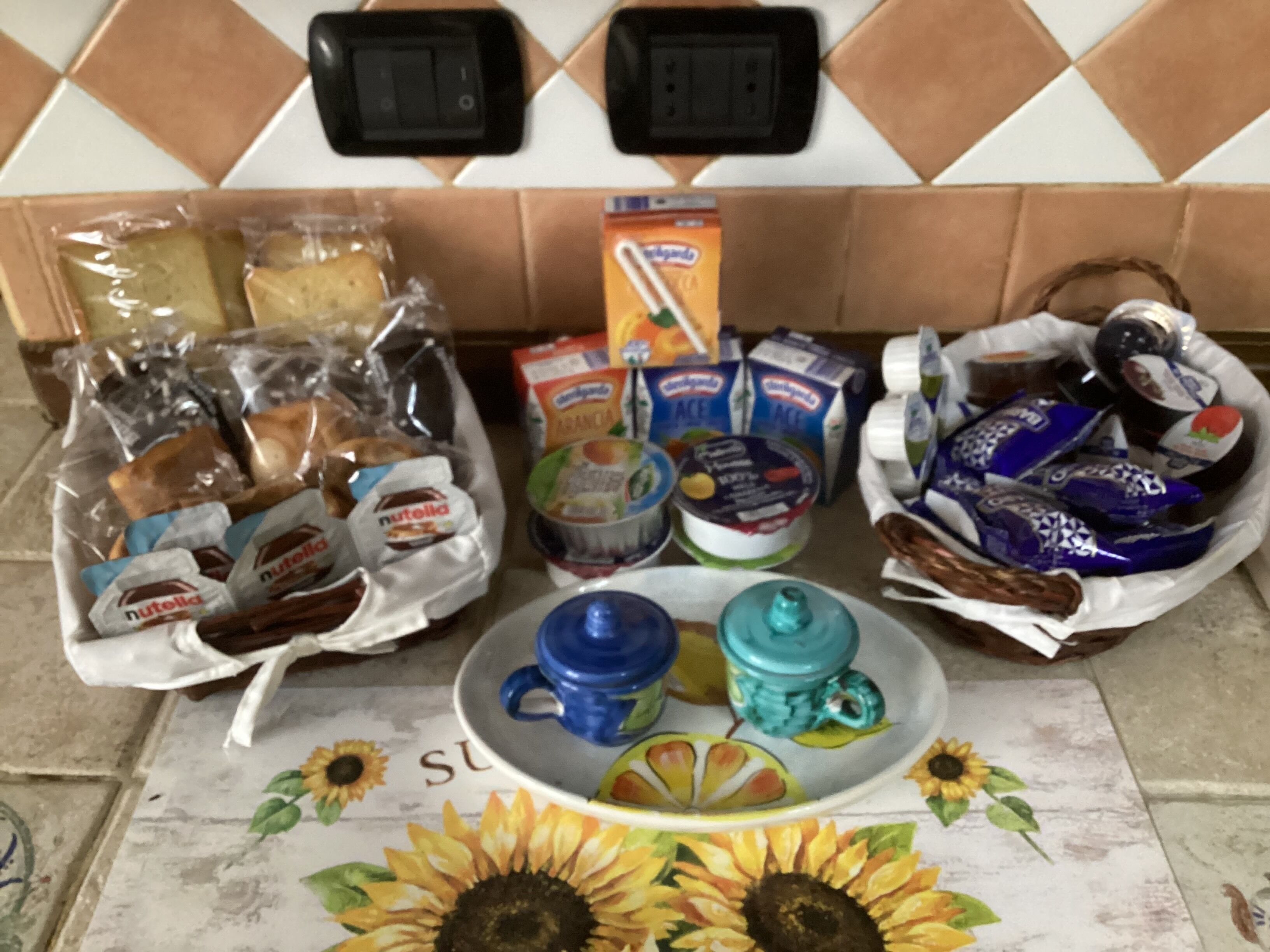 A kitchen counter with various food items, including packaged snacks, bread, and dairy products.