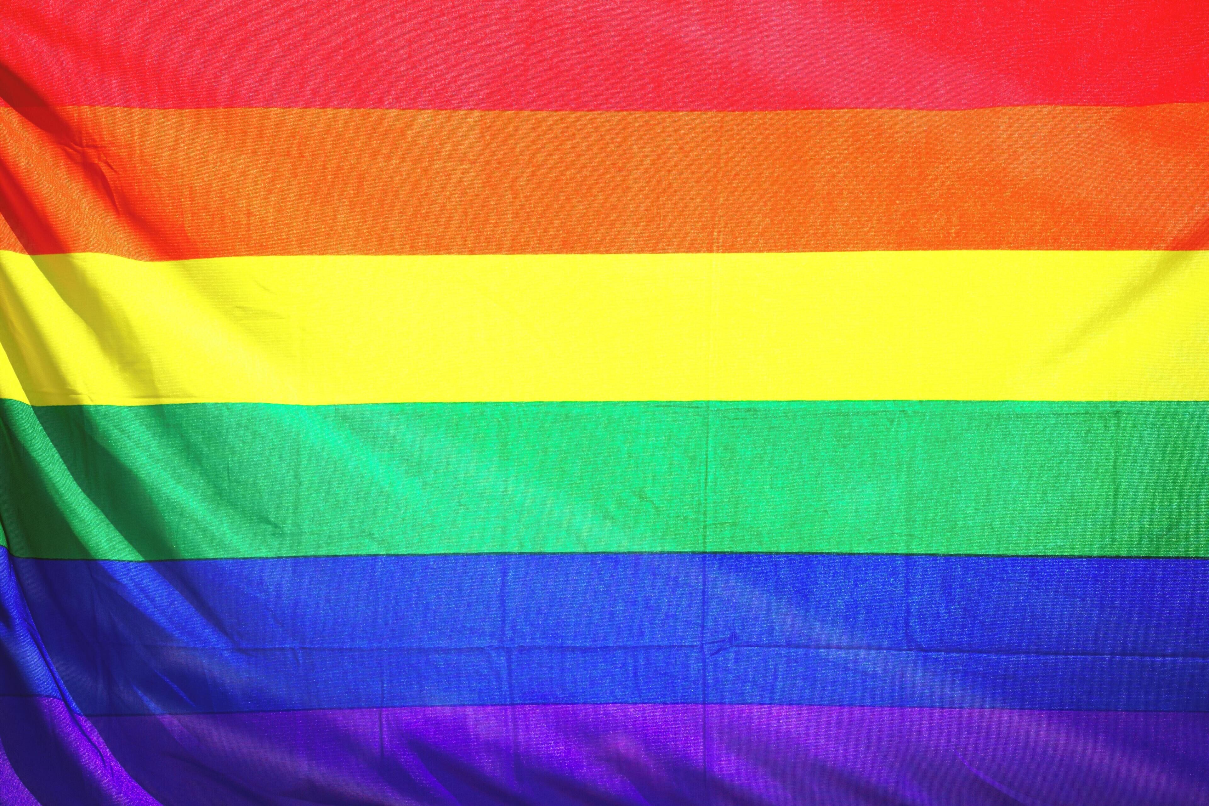 Una bandera amb franges horitzontals de vermell, taronja, groc, verd, blau i morat.