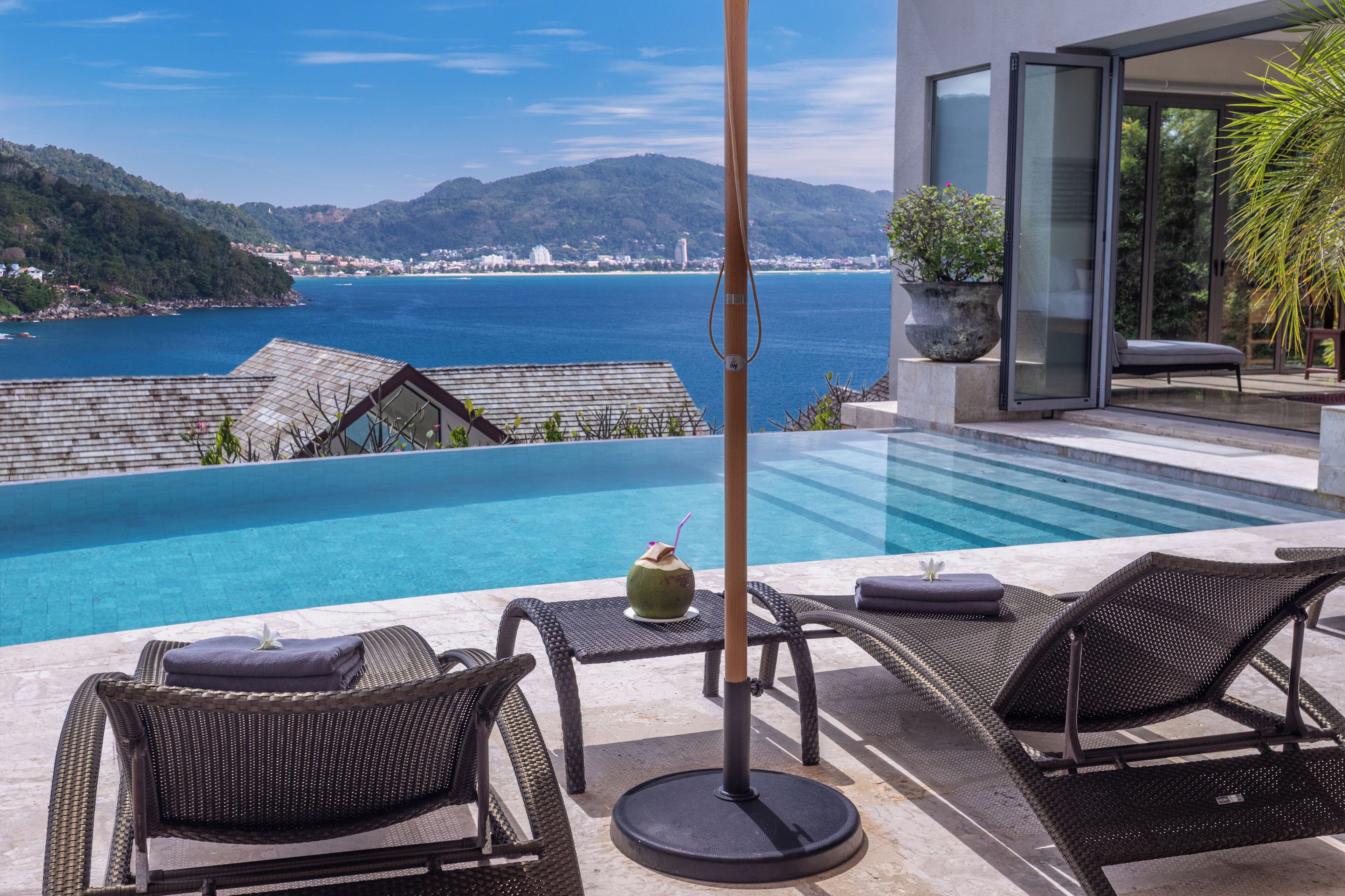 Een buitenzwembad, parasols bij het zwembad en ligstoelen