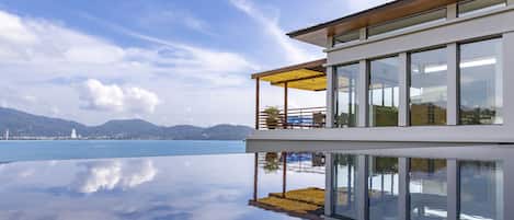 Een buitenzwembad, parasols bij het zwembad en ligstoelen