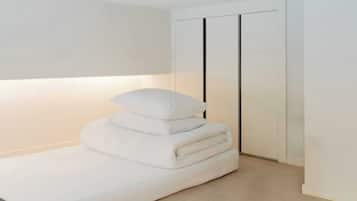 Una cama bien hecha con almohadas en una habitación minimalista con un armario corredero.