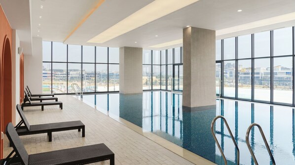 An indoor swimming pool with clear views of the cityscape through large windows. - Le collective Siheung Wavepark (Siheung)