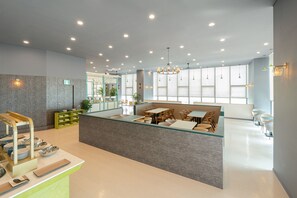 A modern restaurant with a central island, seating area, and a view of the outdoors. - Le collective Siheung Wavepark (Siheung)