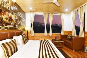 A hotel room with a bed, a sofa, a small table, and curtains.