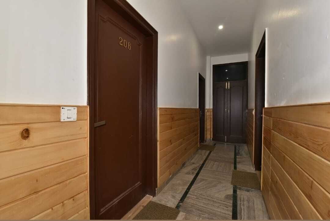 A hallway with wooden walls and a brown door labeled "206".
