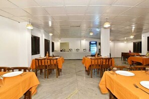 A dining area with tables set for meals, a counter with a menu display, and a clean, tiled floor.