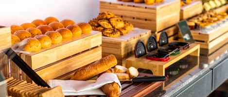 Una vitrina de panadería con diversos productos horneados en cajas de madera.