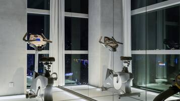 A gym with exercise equipment and large windows.