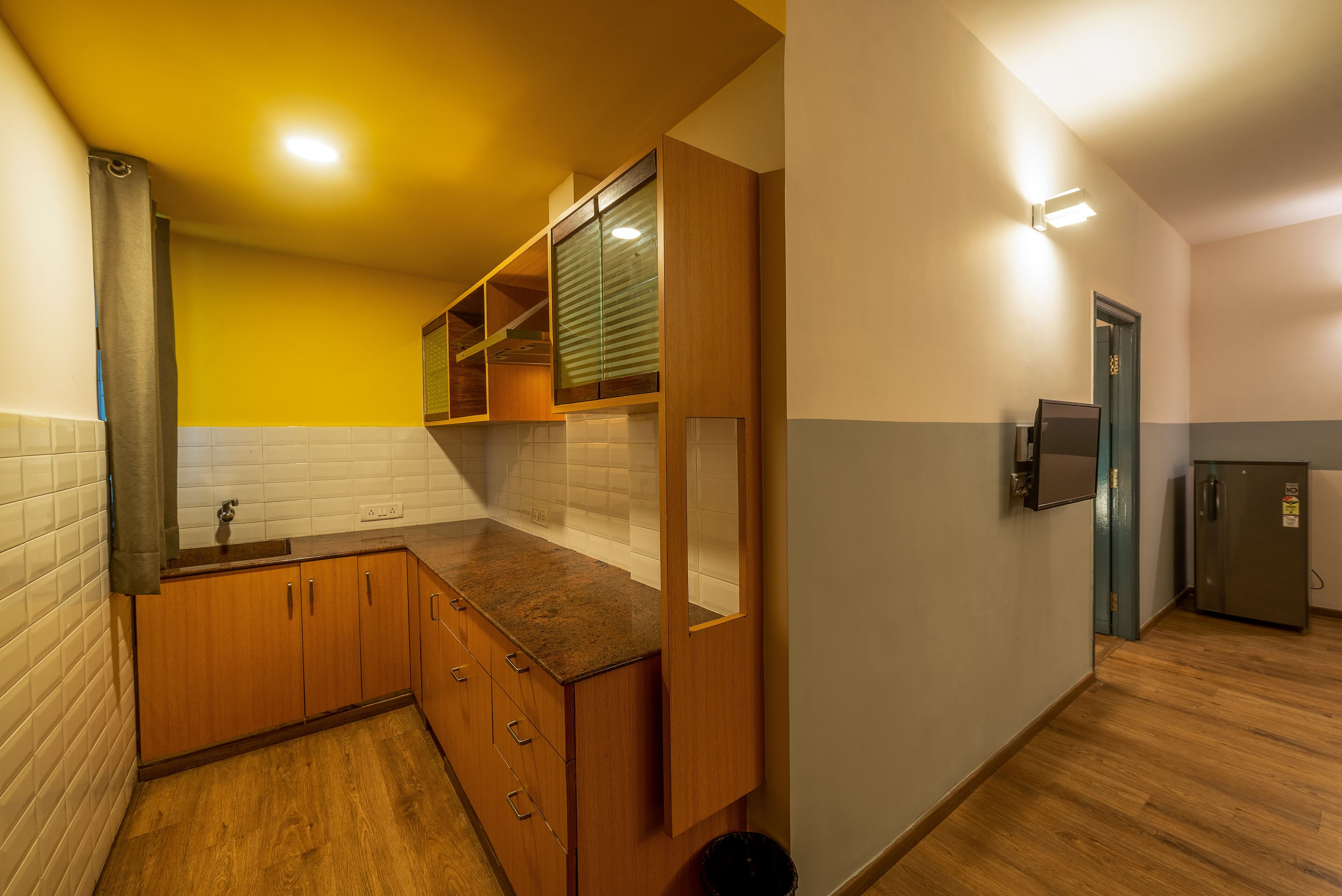 Eine kleine Küche mit Holzausstattung, einem eingebauten Spülbecken und einem Kühlschrank.