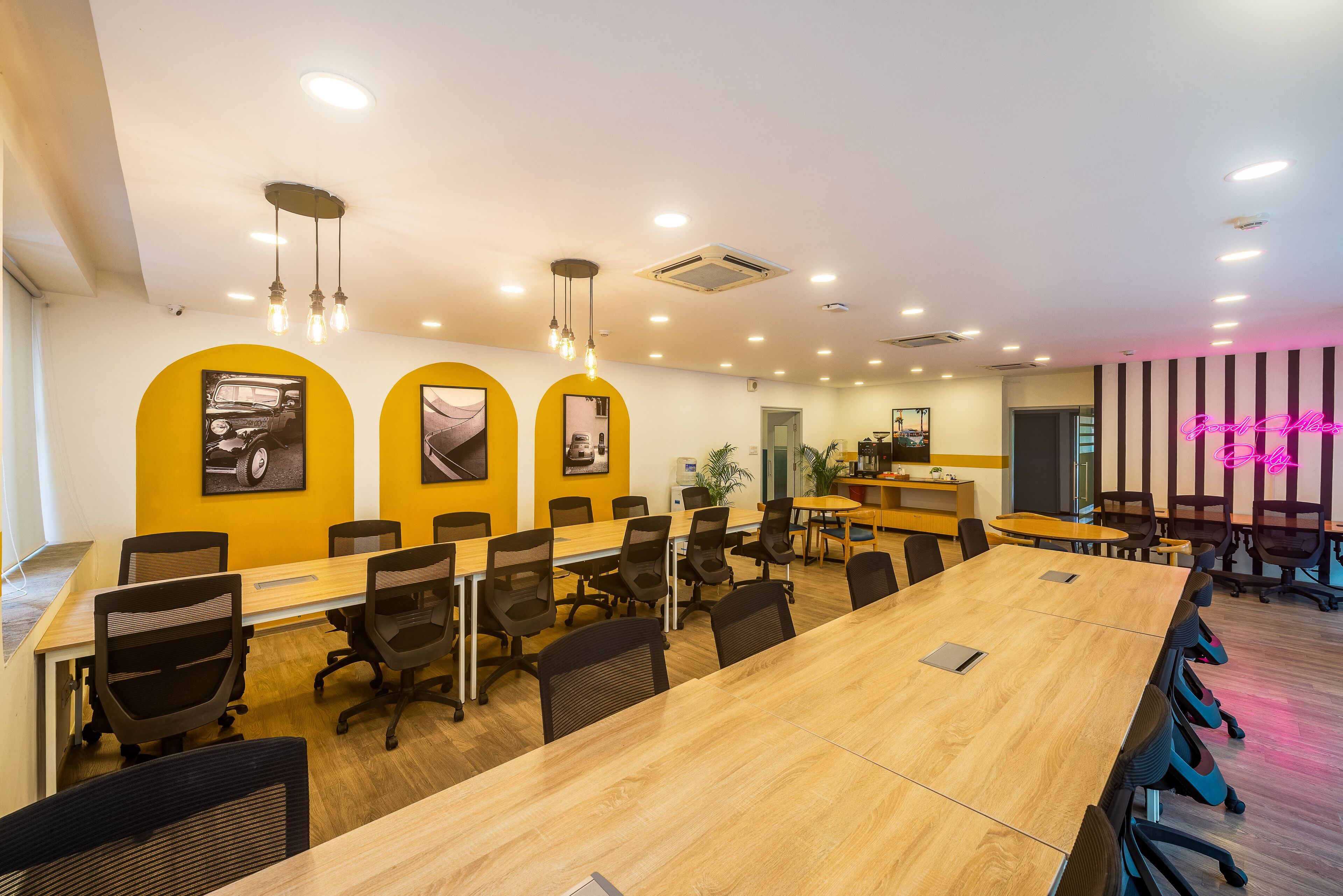 Een vergaderruimte met een lange tafel, meerdere stoelen en een helder plafond met inbouwverlichting.