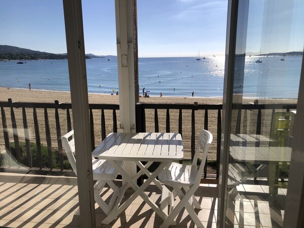 A beach view from a covered patio with a table and chairs. - MerSea Studio, on the beach, 2–4 people (PORT GRIMAUD)