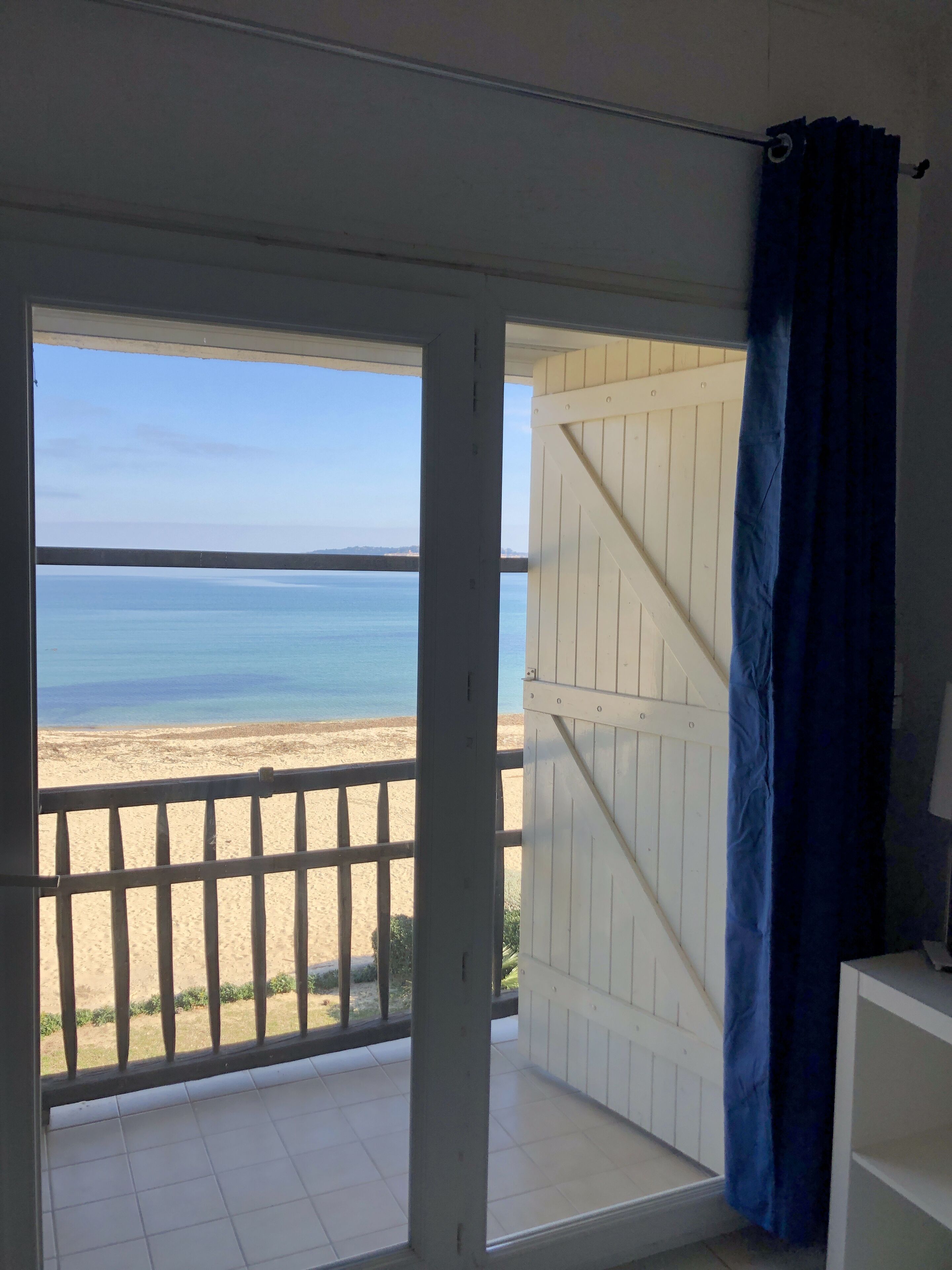 Ein Balkon mit Blick auf Strand und Meer.