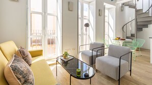 A modern living room with a sofa, armchairs, a coffee table, and a staircase. - Pimienta 9 - Santa Cruz by Valcambre  (Seville)