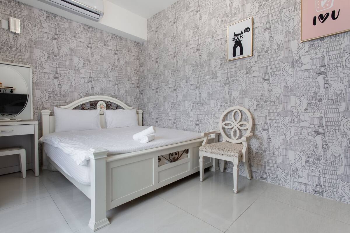 Une chambre bien rangée, avec un lit, une chaise et un bureau.