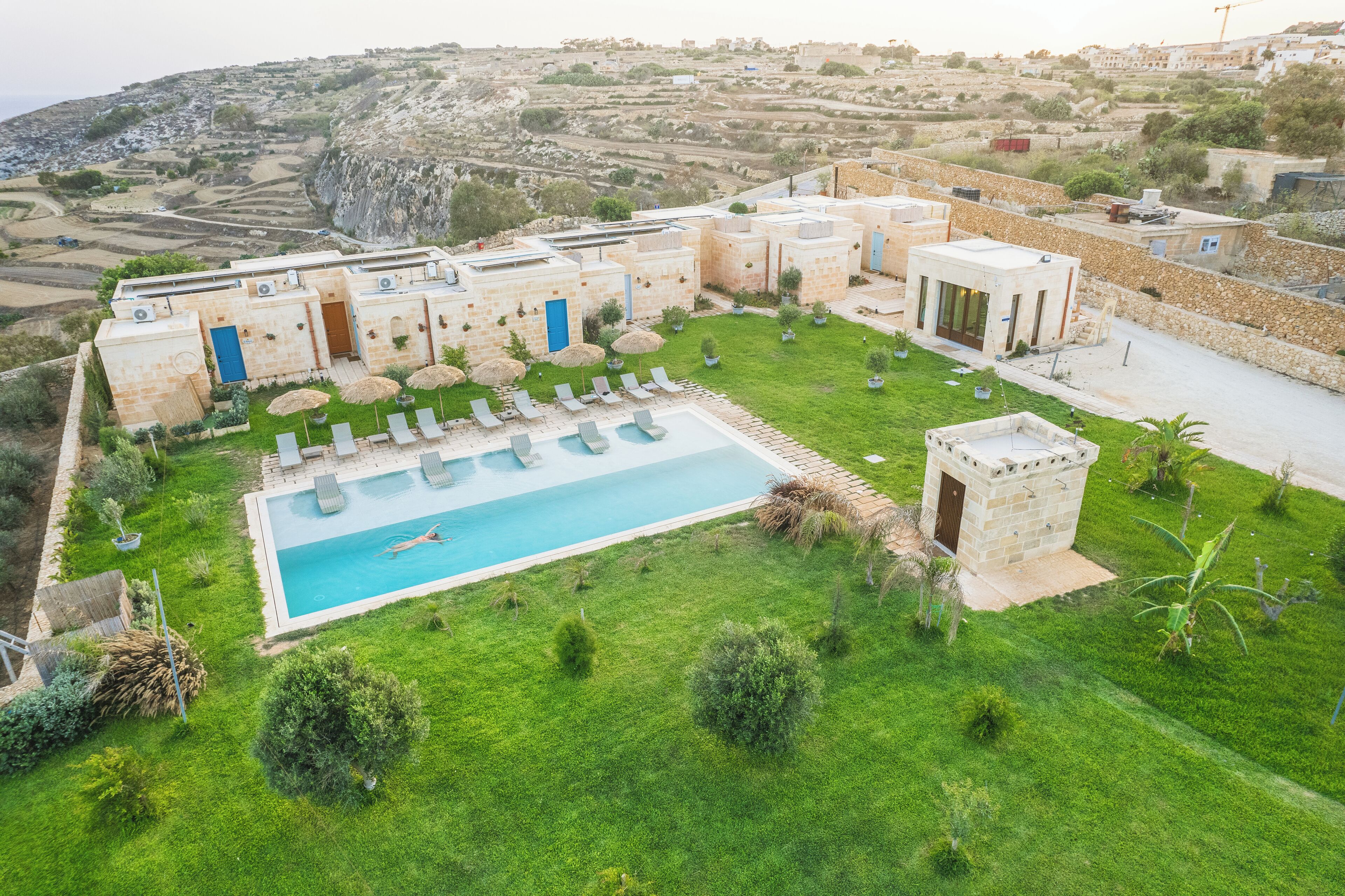 A pool area with lounge chairs and a swimming pool surrounded by a well-maintained lawn and stone buildings. - Tuta Agrotourism  (Kercem)