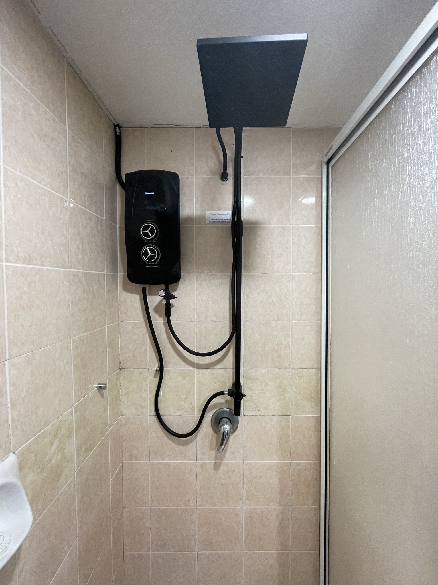 A shower with a control panel and a handheld showerhead.