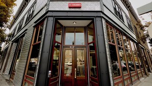 Un edificio ad angolo con un cartello all'ingresso che indica "NO VACANCY" e "Linch Hotel".