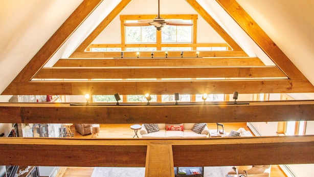A high-ceilinged room with a sloped wooden ceiling, a ceiling fan, and a window providing natural light. - Mountainside 5-BR Ski-In/Out Okemo Retreat (Ludlow)