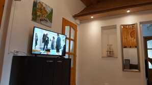 A room with a television on a cabinet, a painting on the wall, a wooden ceiling, and a mirror with a decorative frame. - 1 Bedroom Private vacation home in Vaskeresztes (Vaskeresztes)