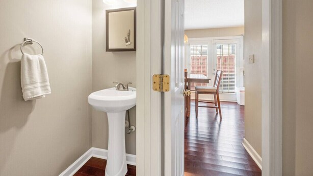Un baño con un lavabo blanco, toallero y espejo.