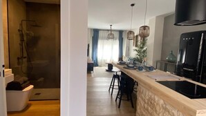 A modern kitchen with a stone countertop, black appliances, and pendant lights. - Nice apartment in the center of Santander (Santander)