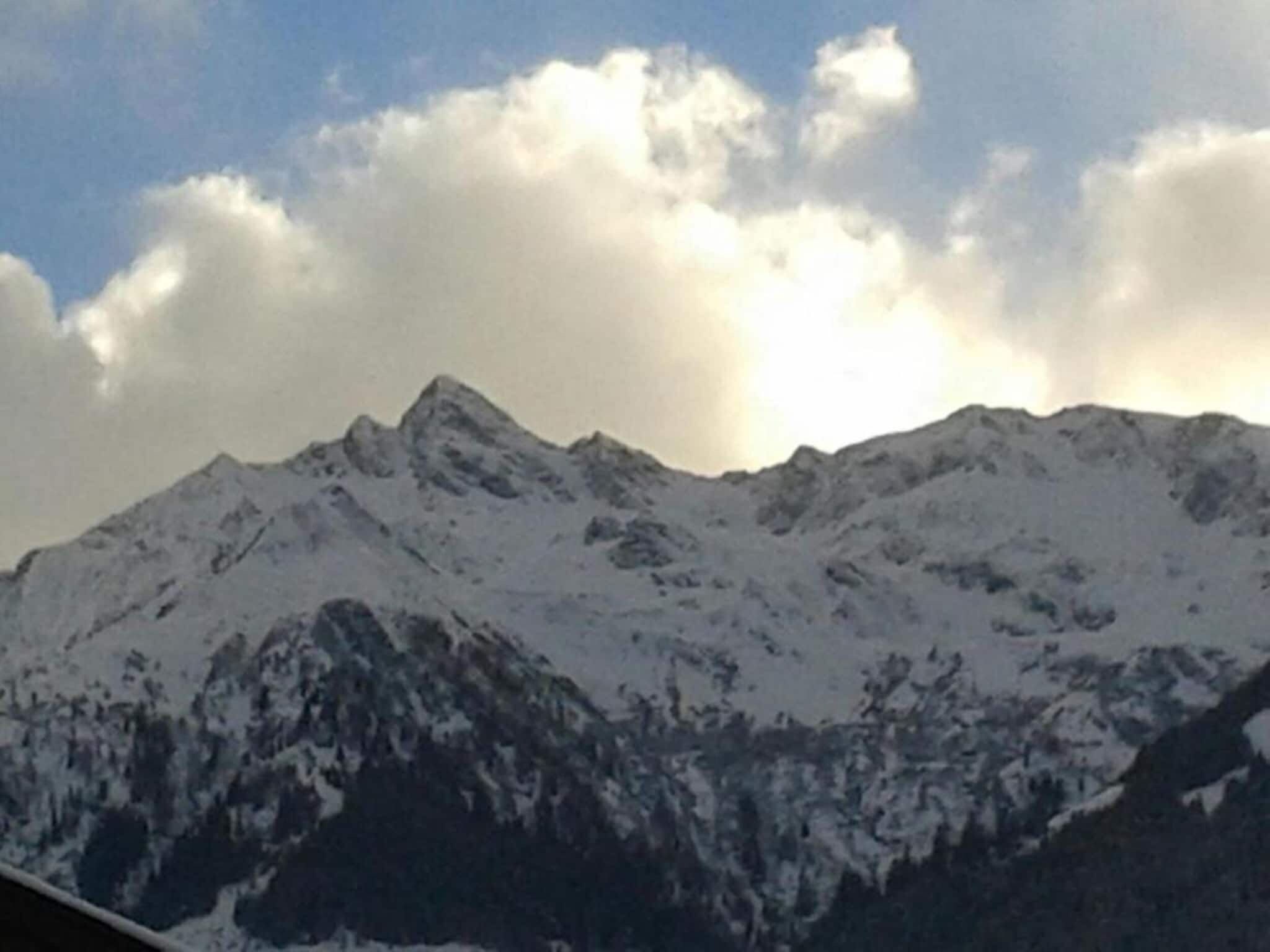 A snow-covered mountain range with rugged peaks and a clear sky.