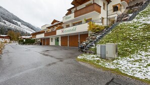 Ett hotell med en träfasad, en balkong och en trappa som leder upp till entrén.